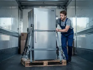 Technik podłącza elastyczny wąż gazowy do nowoczesnej kuchenki, widać zawór odcinający i złącze w czystej kuchni